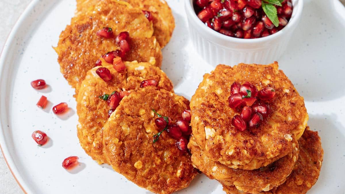 A platter of cottage cheese fritters with pomegranate pearls.