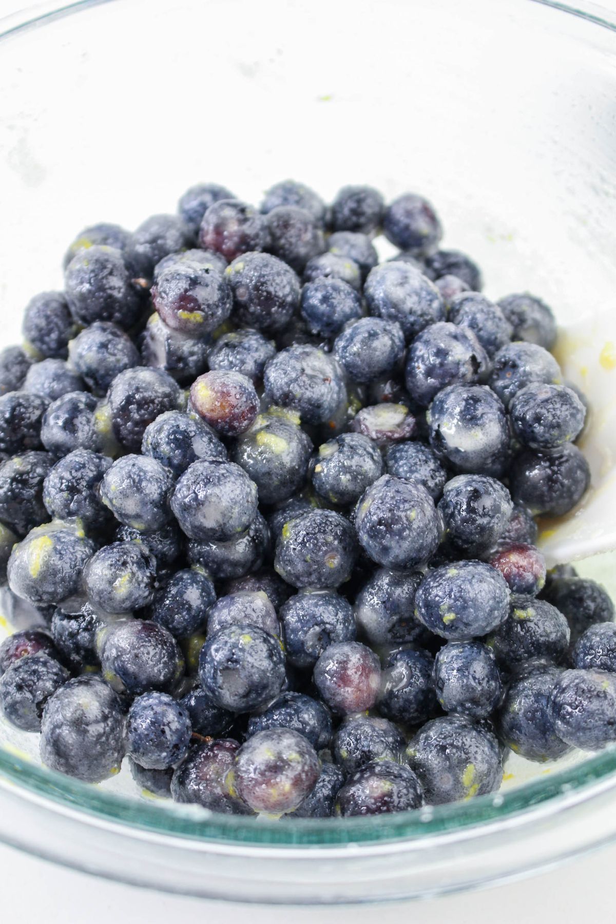 blueberries and filling ingredients being mixed together in a glass bowl.