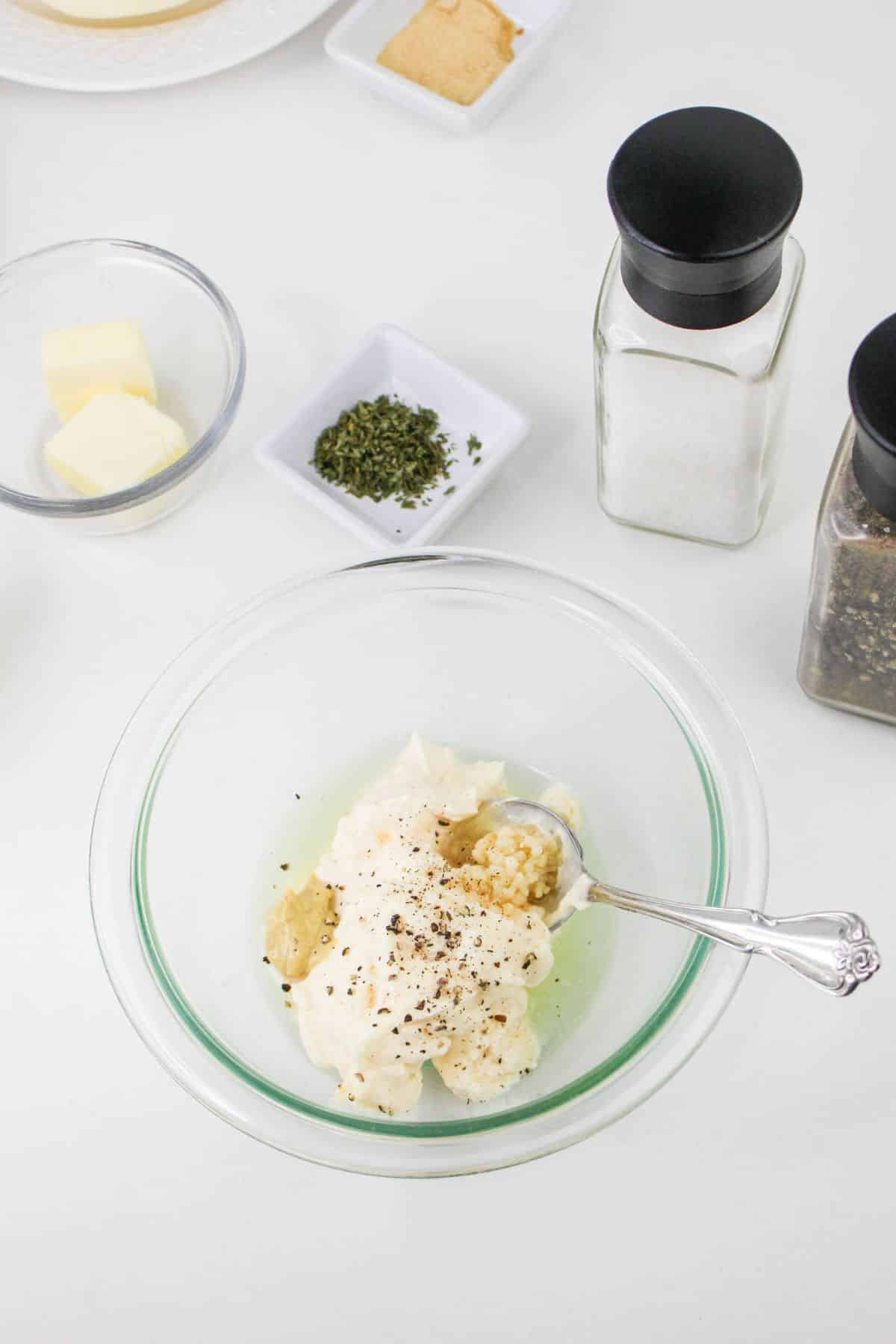 garlic aioli being mixed in a small glass bowl.