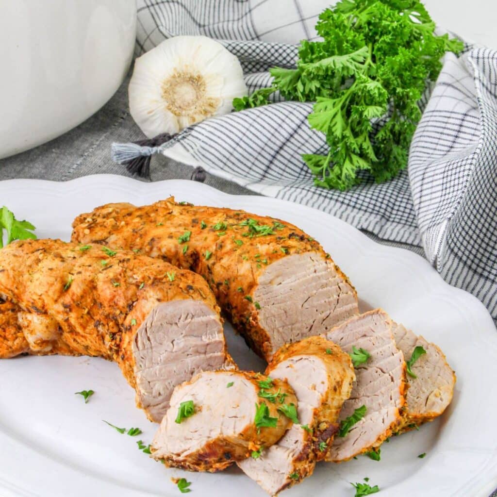 pork tenderloin on being sliced on a plate.
