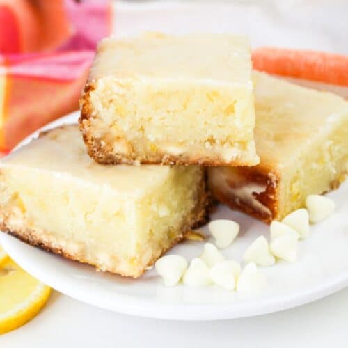 three lemon blondies stacked on a plate.