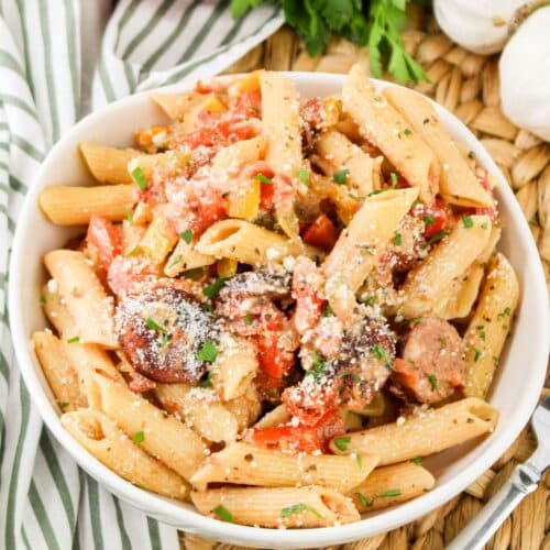 bowl full of smoked sausage pasta on a placemat.