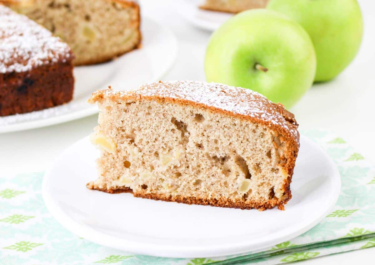 Slice of cinnamon apple cake on a plate.