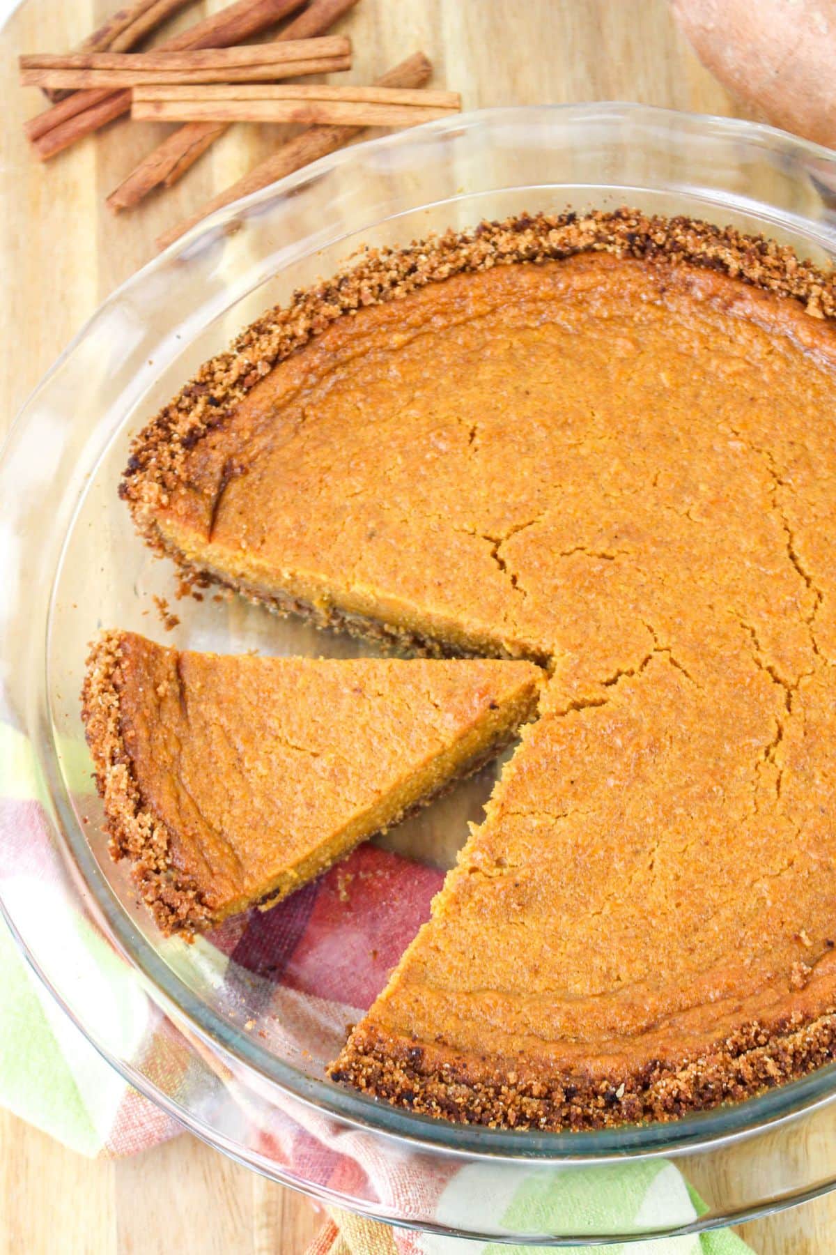 Slice of sweet potato pie being cut and removed from the whole pie.