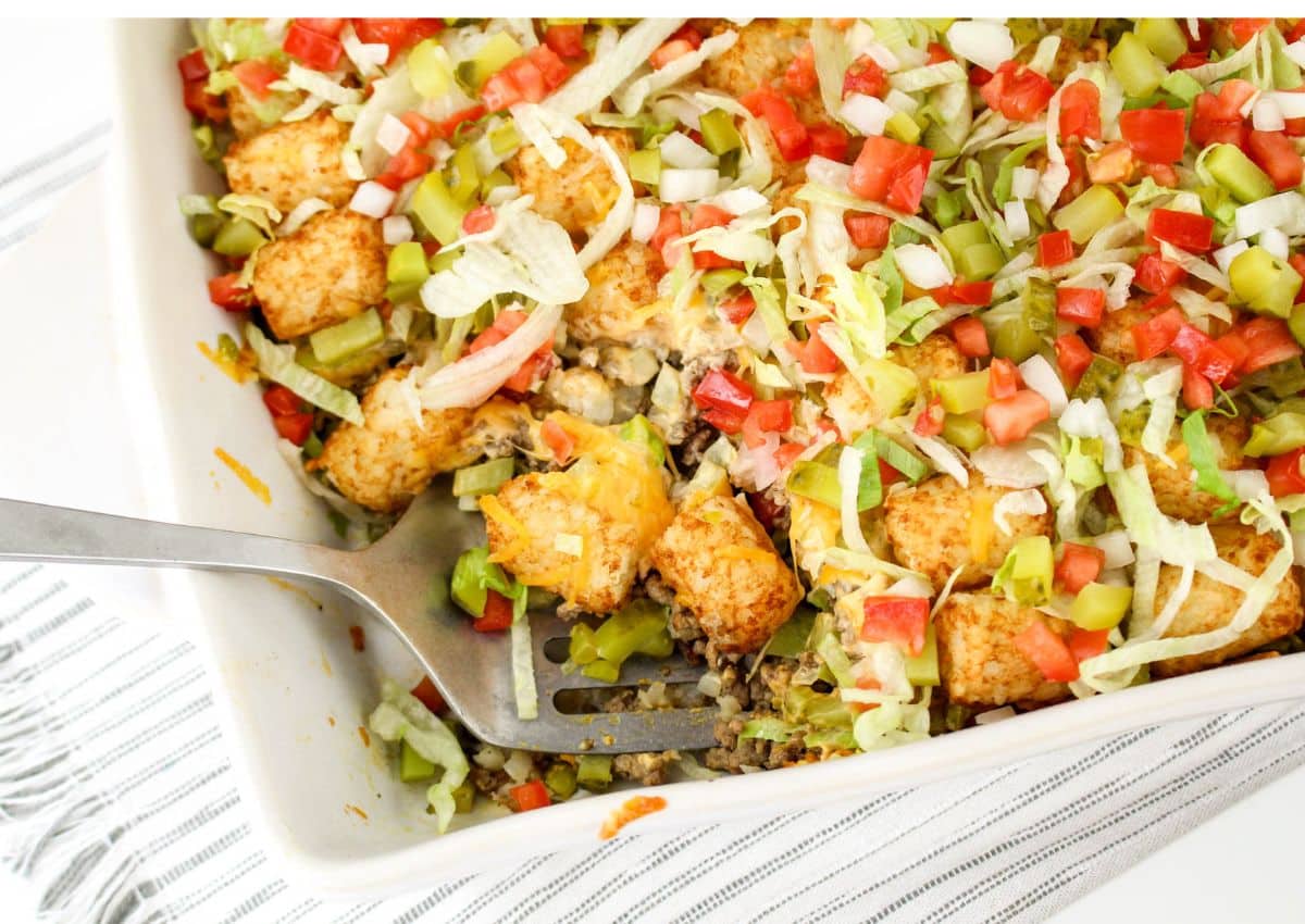 Serving of tater tot casserole being removed form the baking dish.