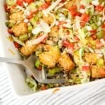 Serving of tater tot casserole being removed form the baking dish.