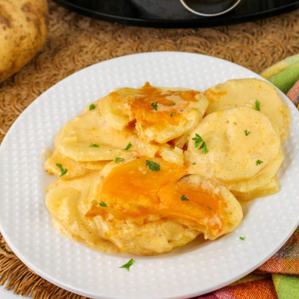 Plate with a serving of au gratin potatoes on it ready to serve.