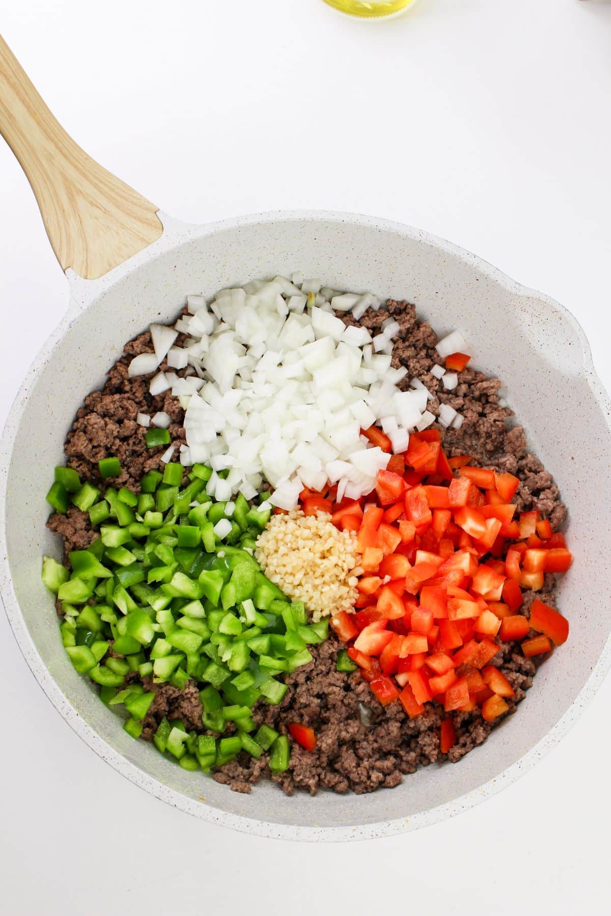 diced onion, bell peppers, and minced garlic to the skillet with the ground beef