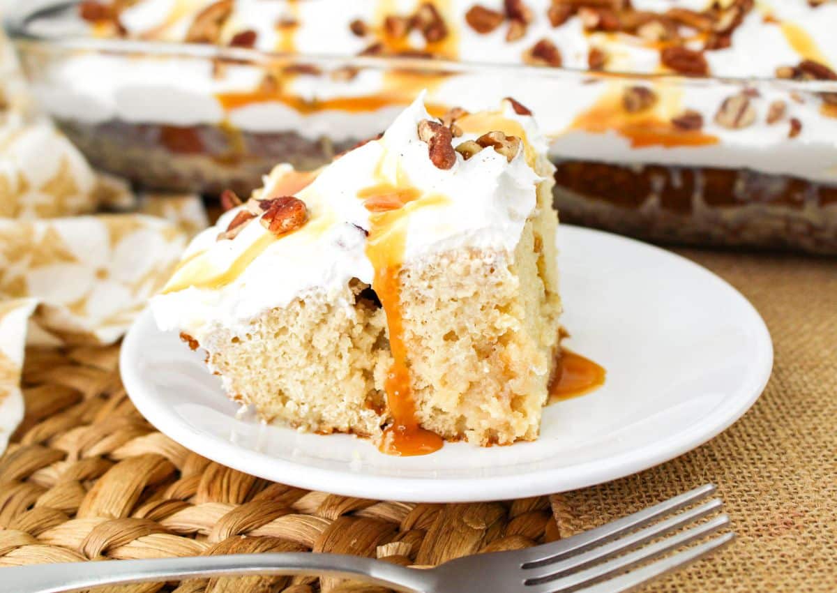 Slice of butter pecan poke cake on a plate.