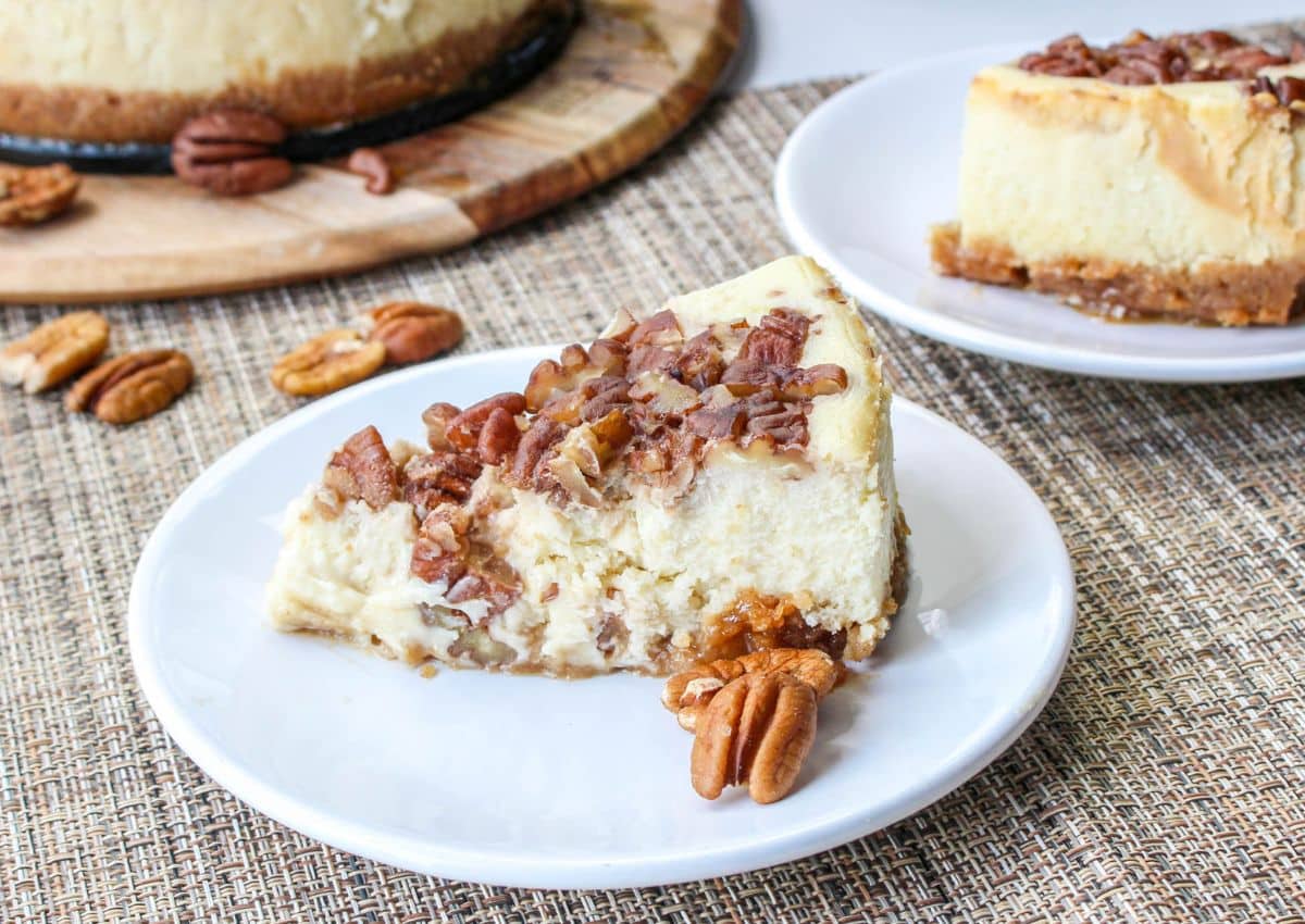 Slice of pecan pie cheesecake on a plate.