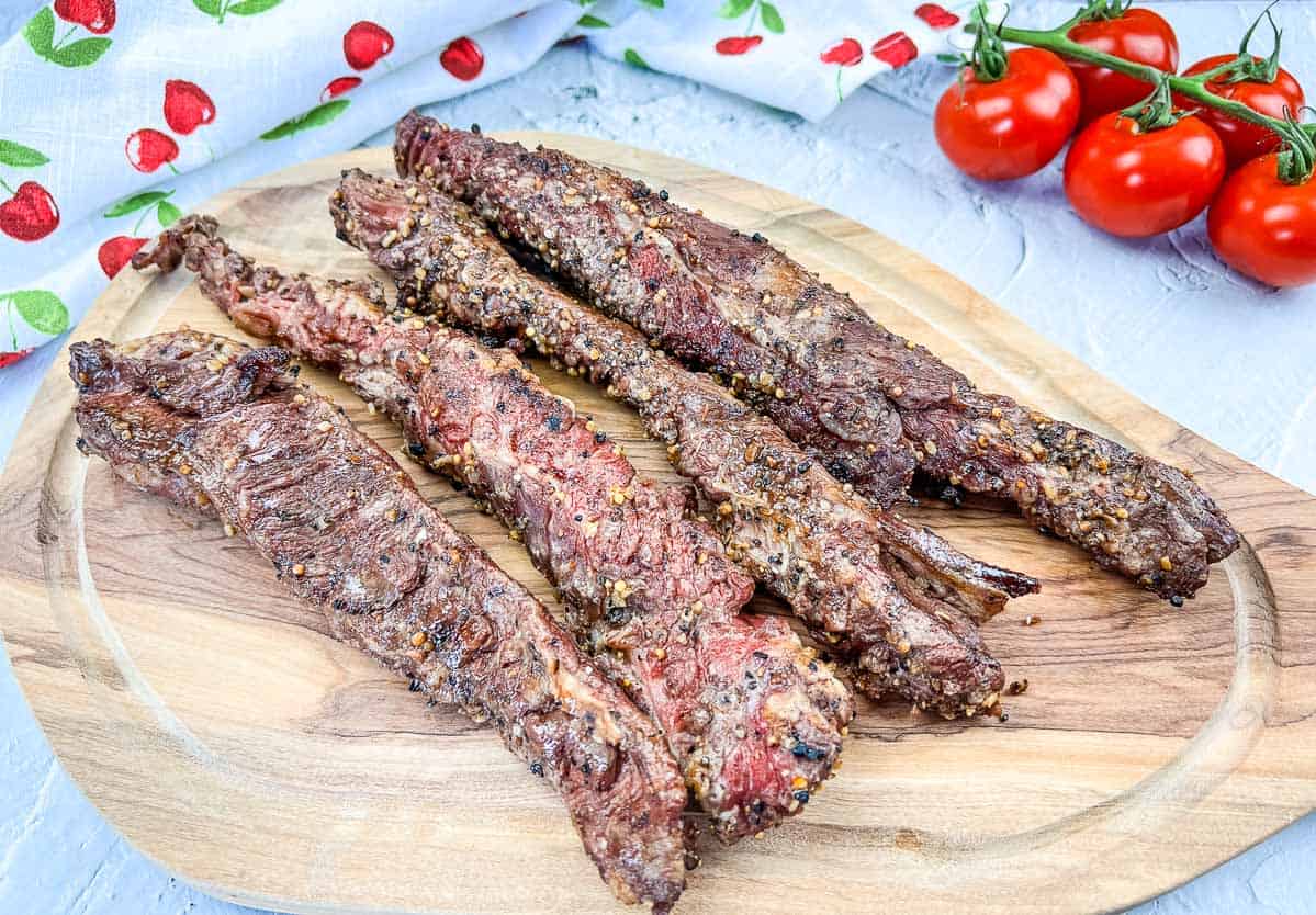 Grilled Beef Finger Meat on a wooden cutting board.