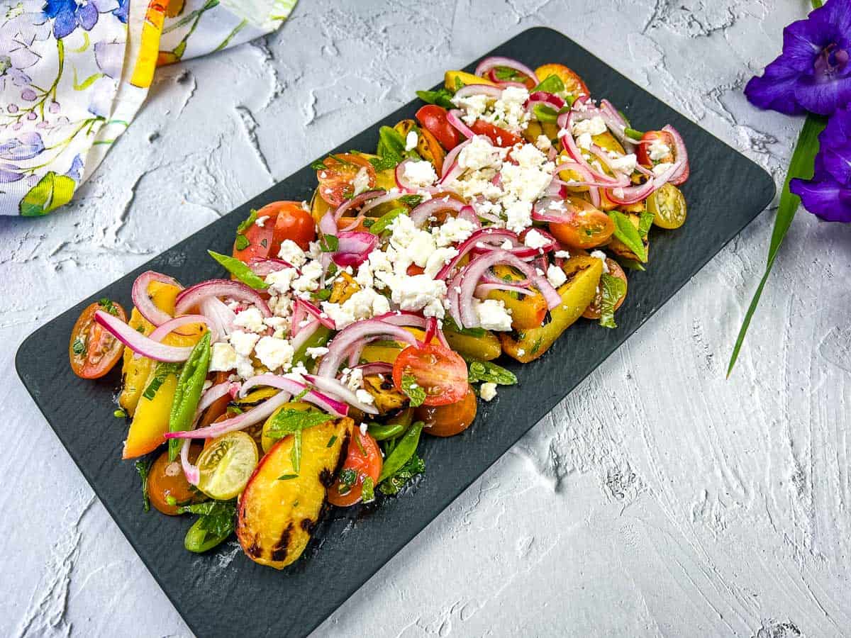 A plate with Grilled Peach Salad with Tomatoes.