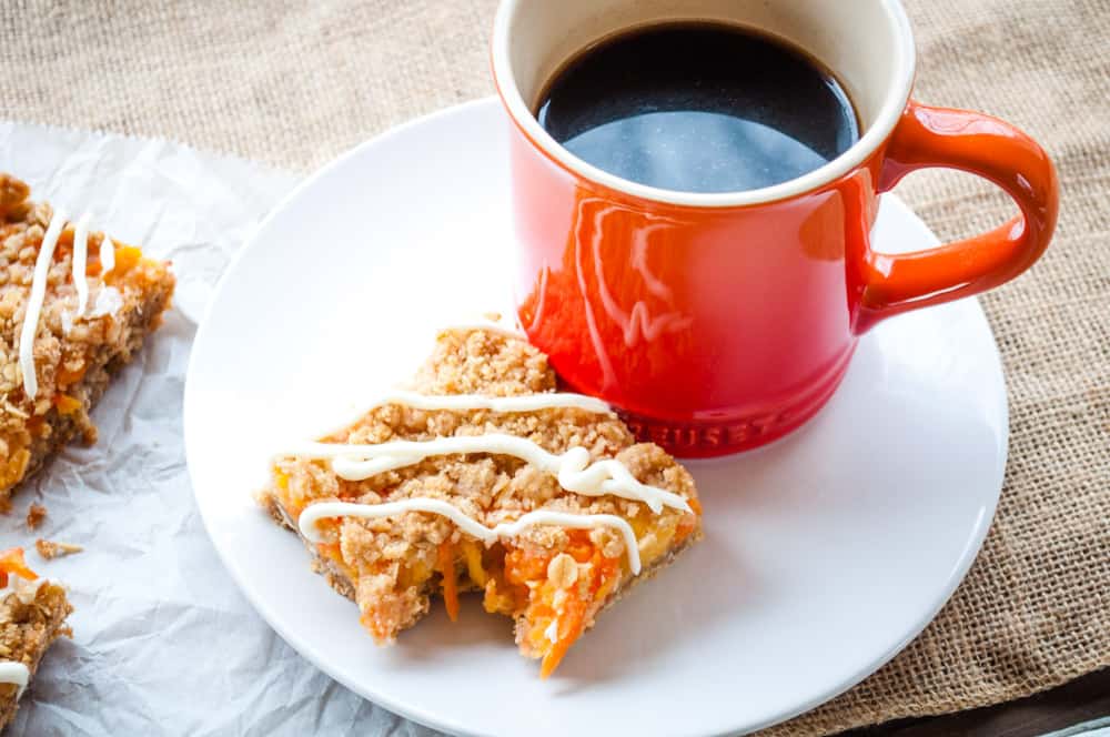 Carrot cake bar with a mug of black coffee on the side.