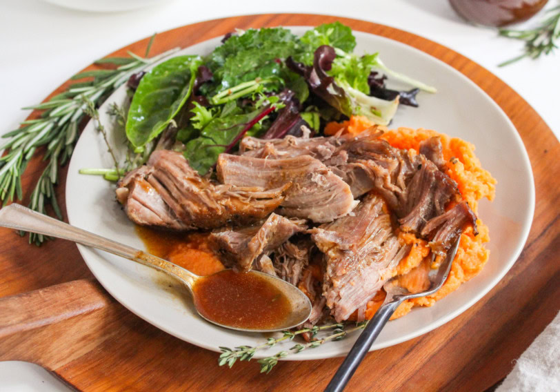 Plate with shredded roast meat and sides.