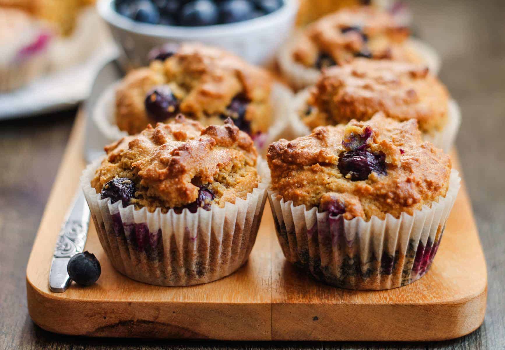A batch of Almond Flour Blueberry Muffins on a counter.