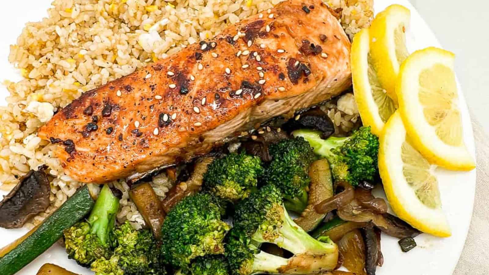 Flavorful hibachi-style salmon on a plate with vegetables and lemon slices.