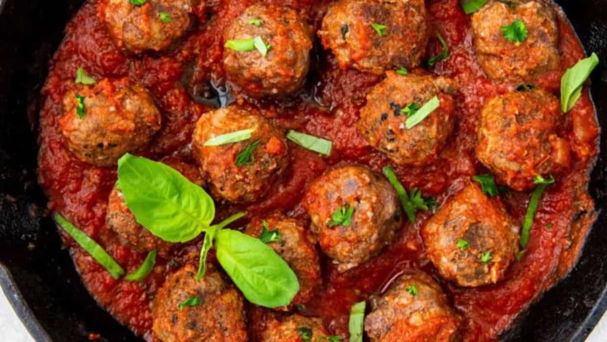 Easy Keto Cast Iron Meatballs in a cast iron skillet with basil.