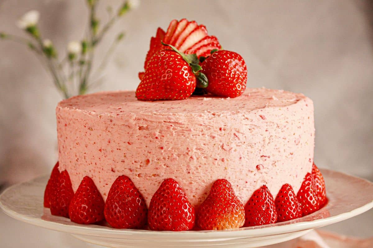 Strawberry cream cake on a cake stand.