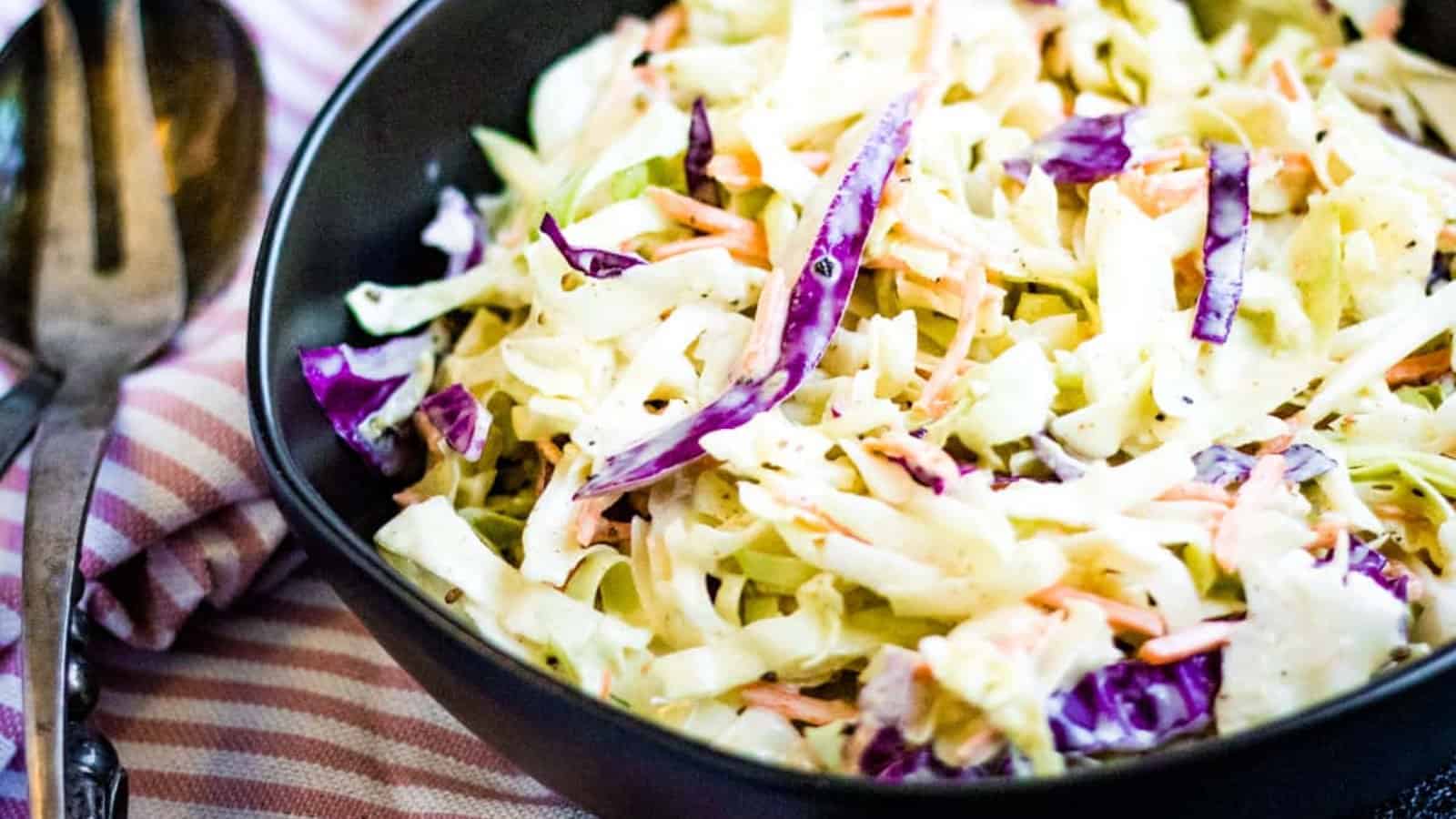 Low angled shot of coleslaw in a black bowl.