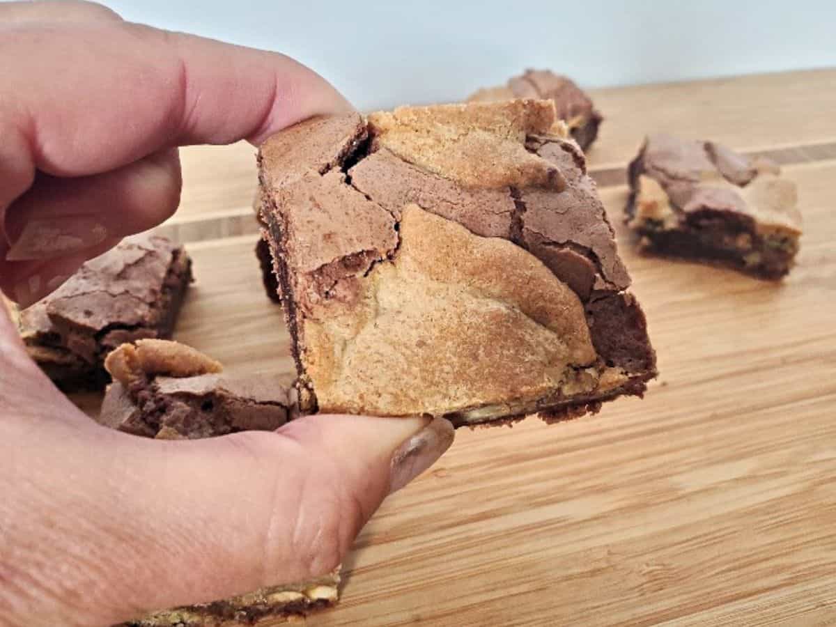 Image shows a close up of Candy Cookie Brownies on a wooden board.
