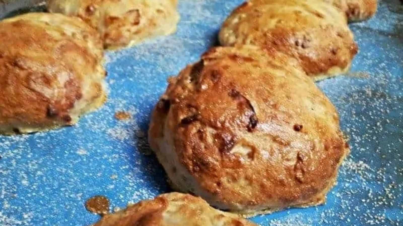 Image shows Goat Cheese and Caramelized Onion Rolls on a blue silpat coated with cornmeal.