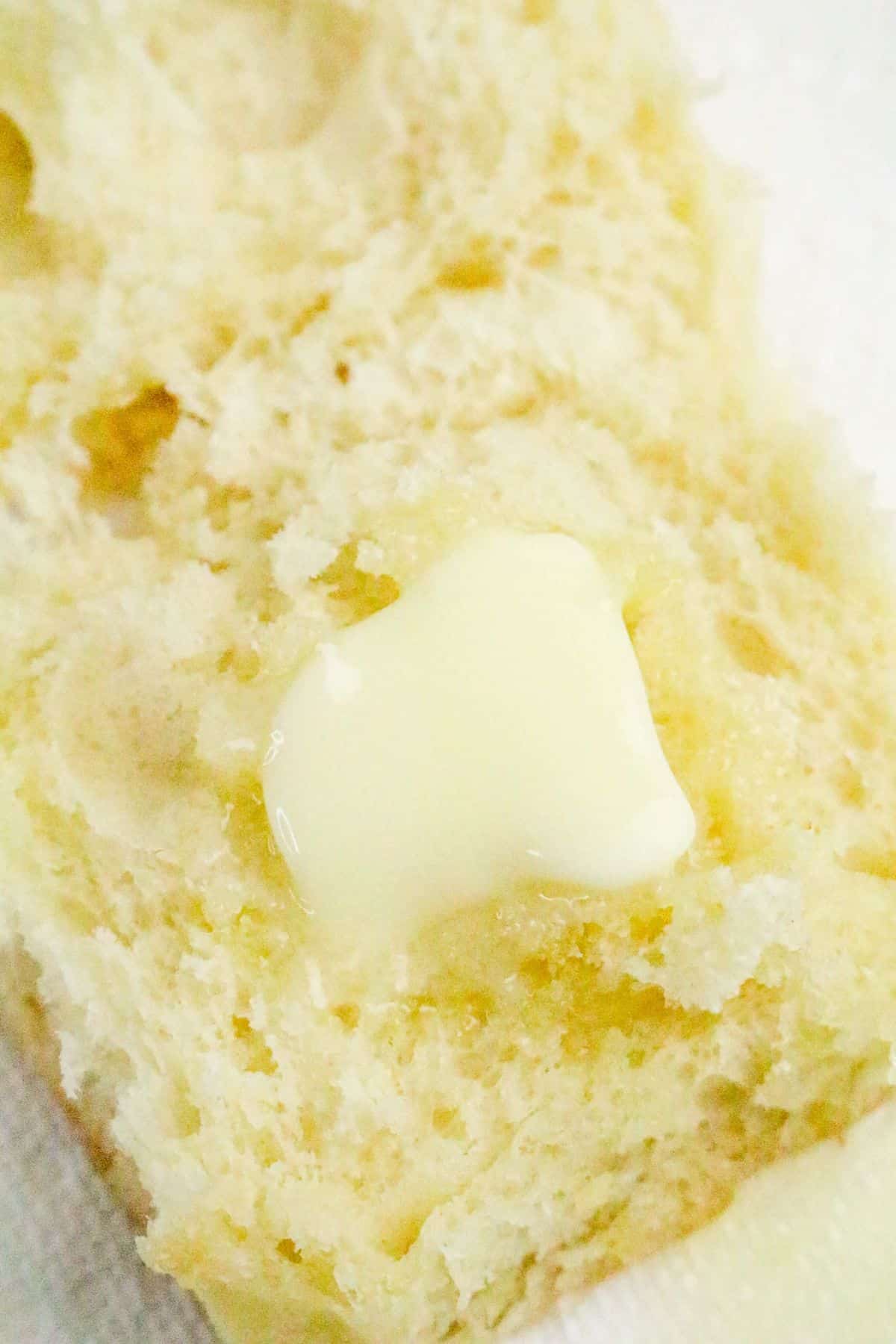 A close-up of a piece of bread with a small amount of melted butter on top.