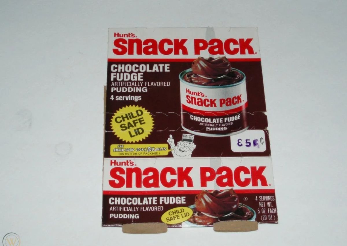 Hunt’s Snack Pack Chocolate Fudge pudding packaging, advertising 4 servings, artificial flavor, and a child-safe lid, with a visible €5.50 price sticker.