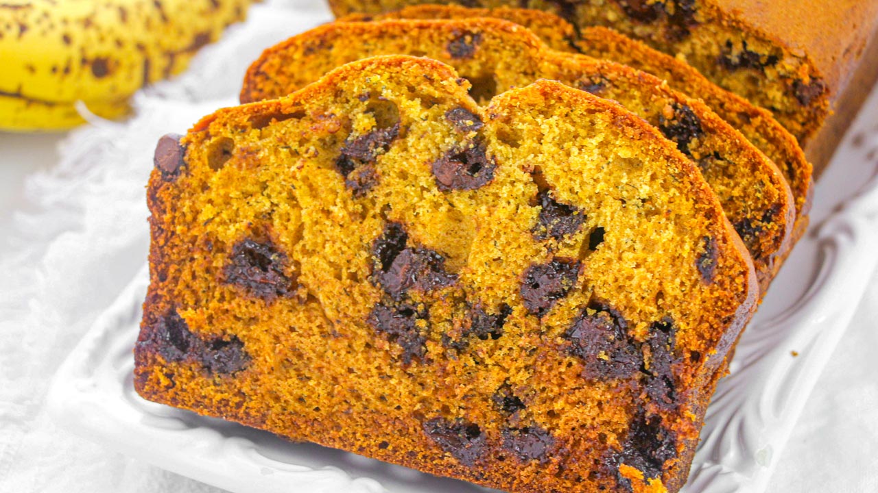 Sliced banana bread with chocolate chips displayed on a white tray.