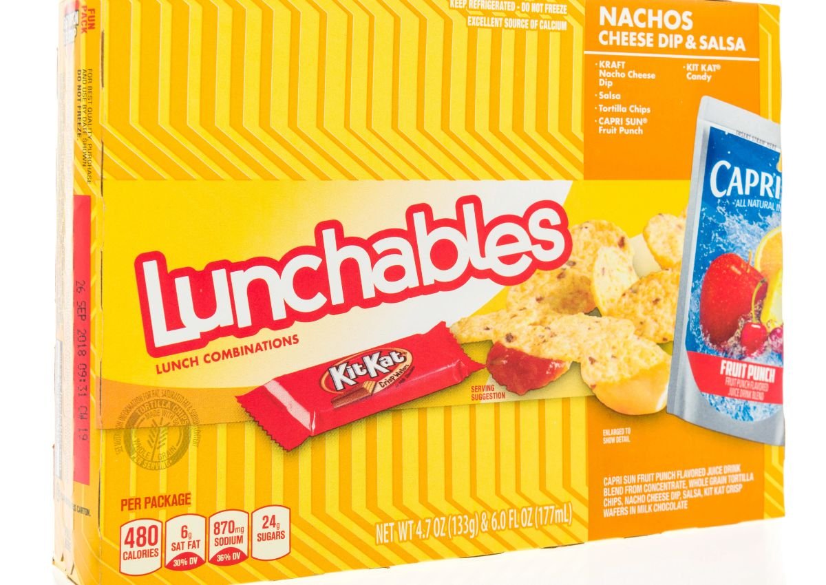 A box of Lunchables Nachos Cheese Dip & Salsa with a Kit Kat bar and Capri Sun Fruit Punch, displaying nutritional information on the front.