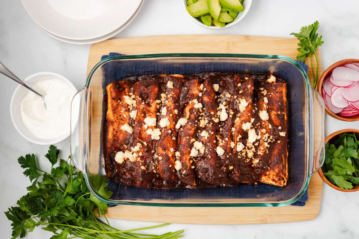An overhead image of black bean enchiladas in a baking dish.