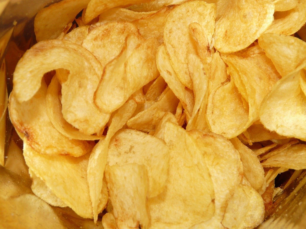 A close-up view of a pile of plain potato chips inside a bag.