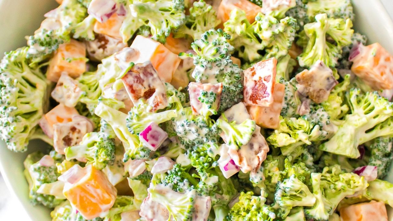 Broccoli salad with chopped cheddar cheese, red onions, bacon, and a creamy dressing.