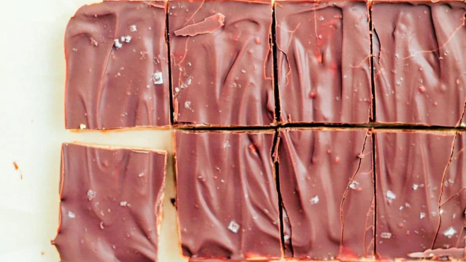 A close-up of chocolate bark cut into rectangular pieces, some sprinkled with coarse salt.
