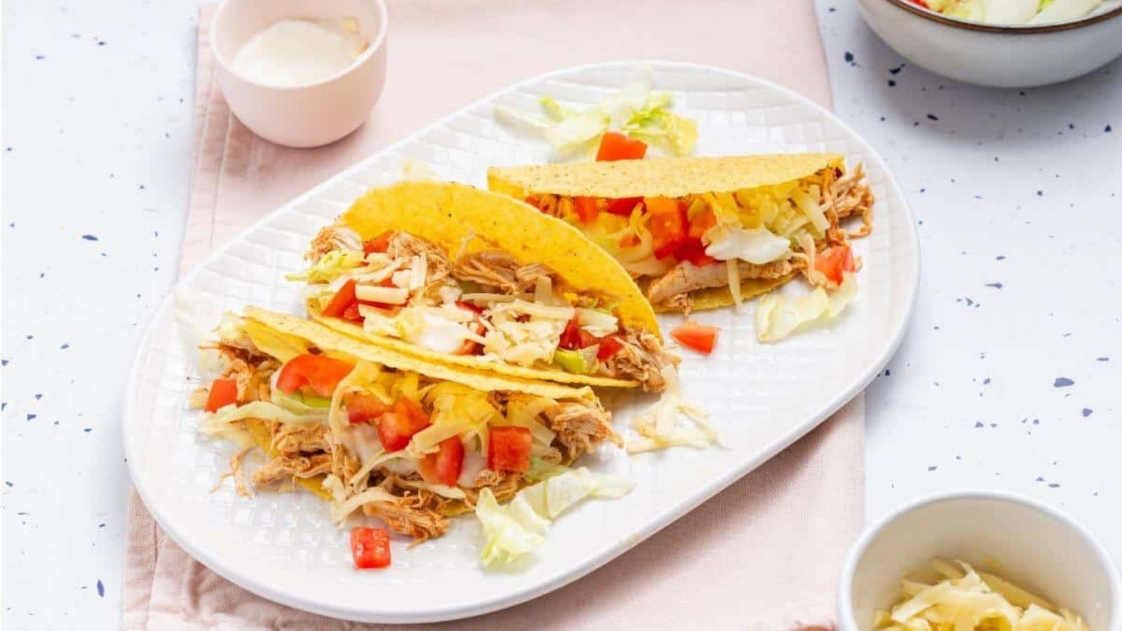 Cheesy potato casserole topped with crispy bacon and chopped green onions in a black dish.