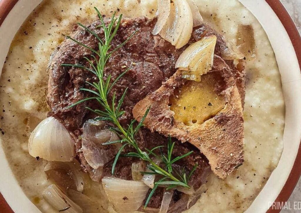 A picture of an easy beef shank slow cooker recipe over cauliflower mash with rosemary.