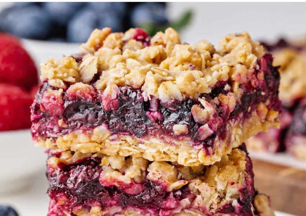 Stack of berry bars with berries in the background.