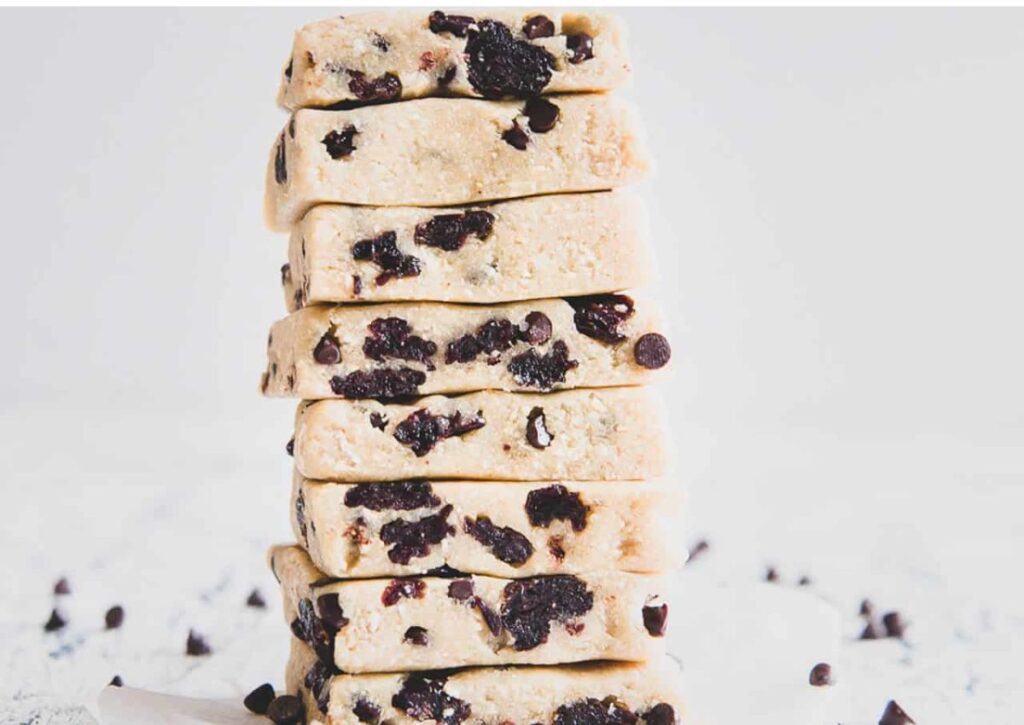 Healthy cookie dough bars stacked high on parchment paper.