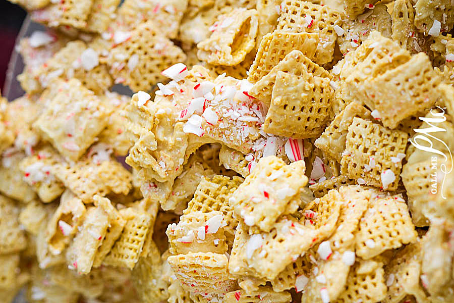 Close-up of Chex cereal squares coated in white chocolate and topped with crushed peppermint candy pieces.