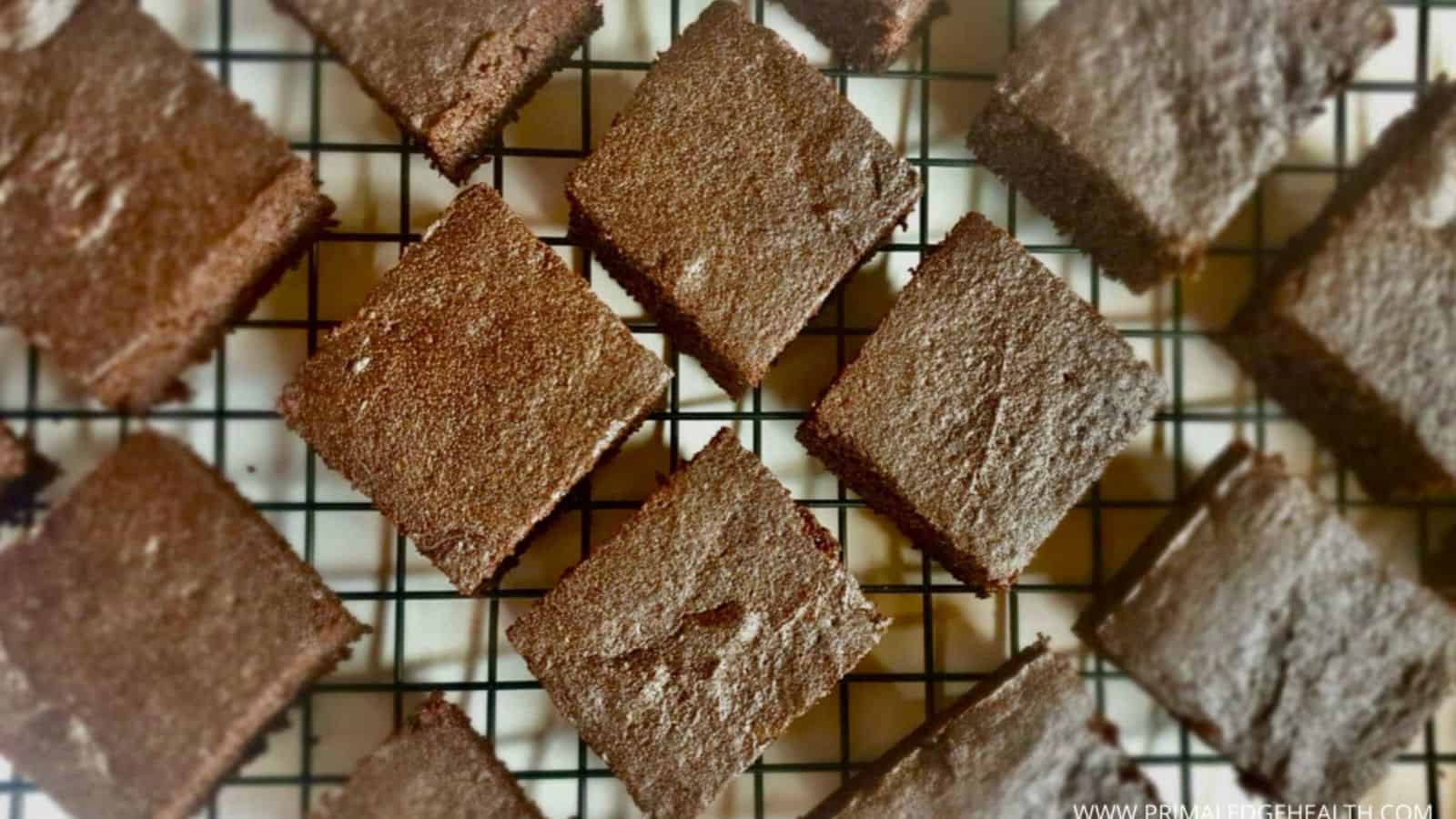 Brownie squares arranged on a black wire cooling rack, viewed from above.