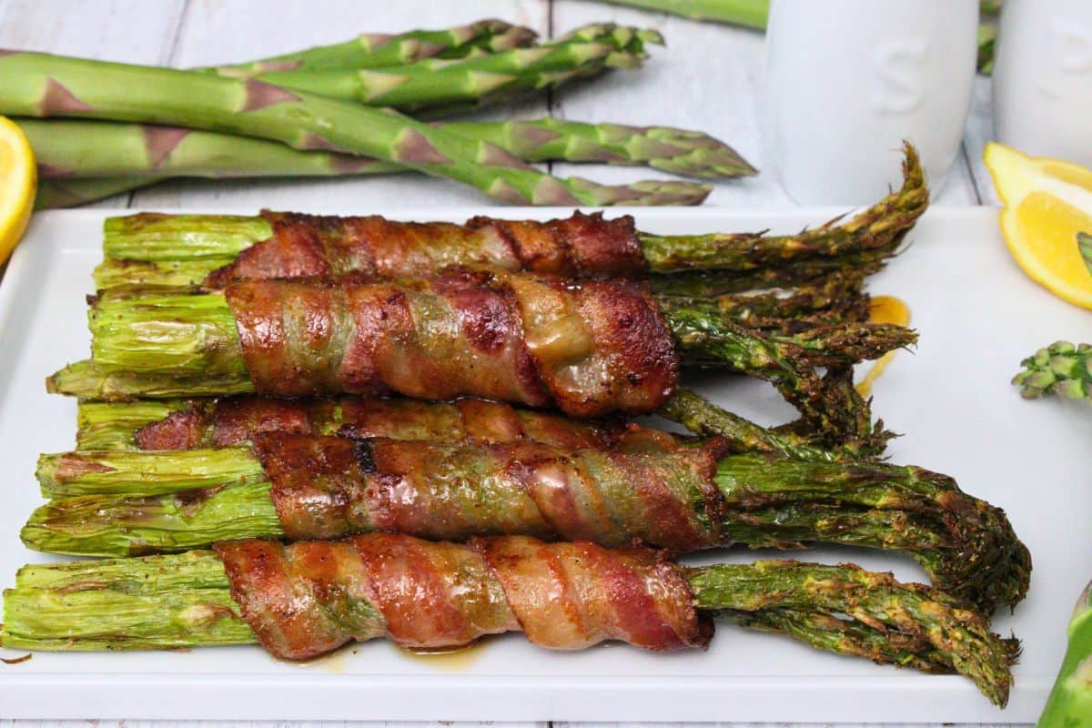 A plate of asparagus wrapped in bacon.