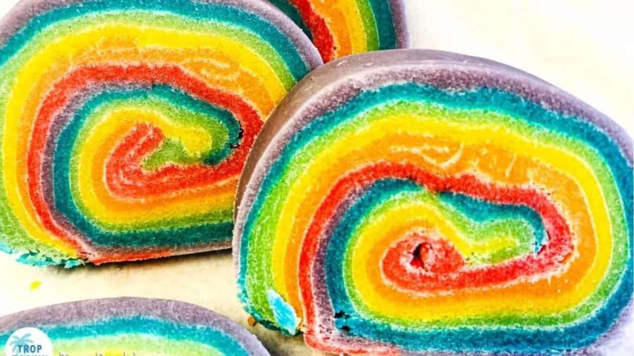 Close-up of sliced rainbow swirl bread with vibrant layers of purple, blue, green, yellow, orange, and red.
