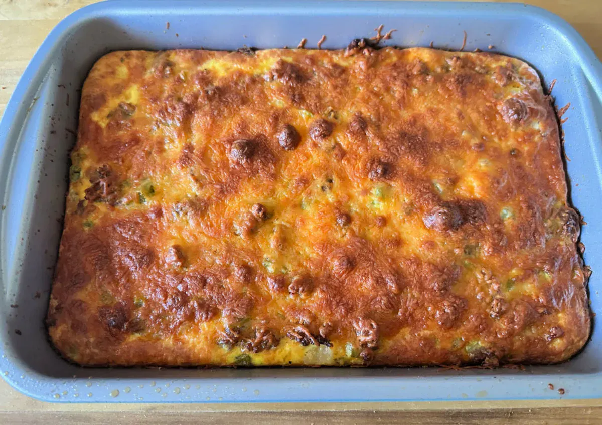 A baked casserole with a golden brown, bubbly cheese topping in a rectangular baking dish.
