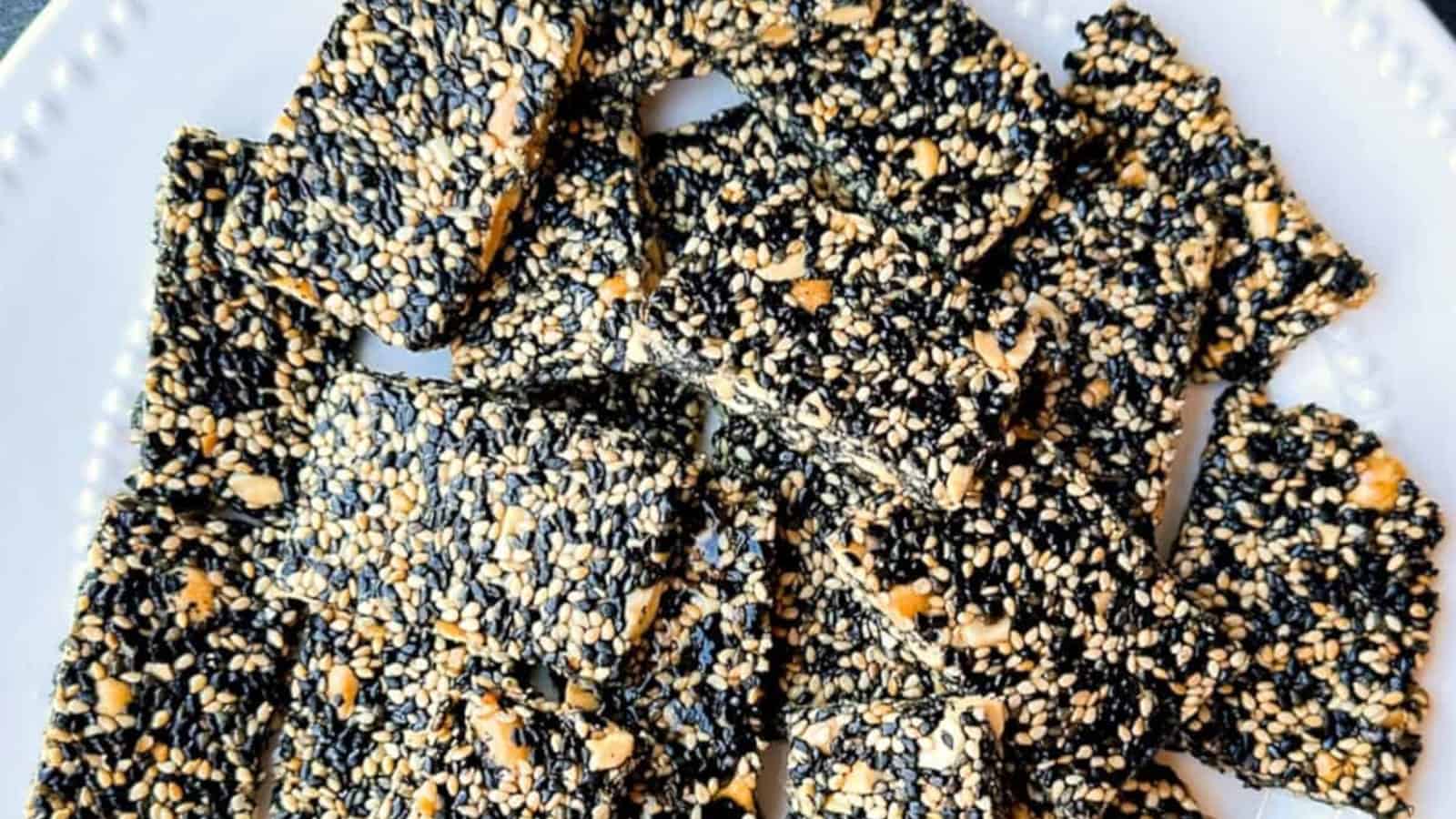 Rectangular pieces of black and white sesame seed brittle arranged on a white plate.