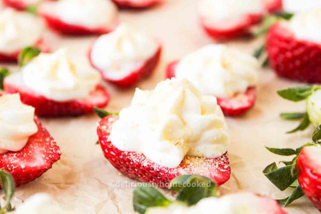 A group of strawberries with whipped cream on top.