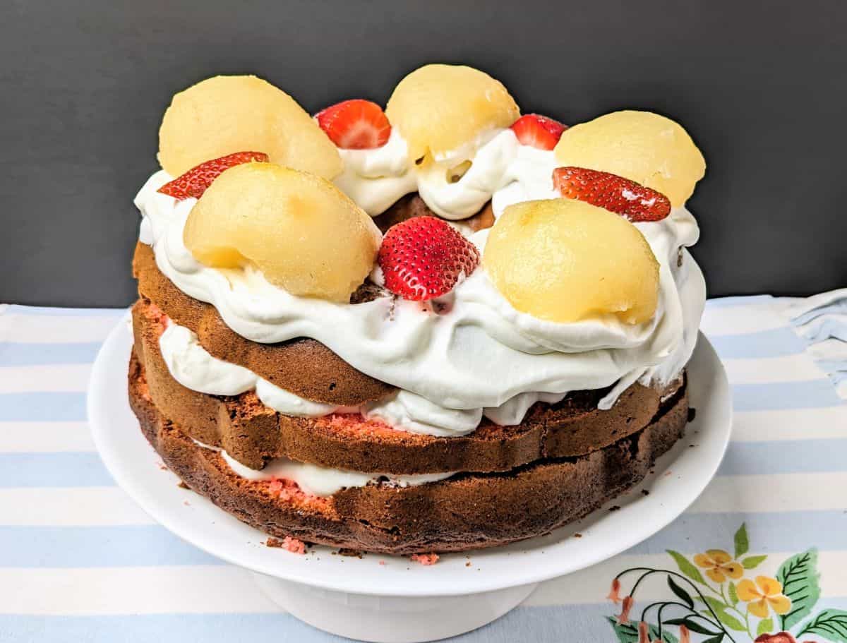 A cake with whipped cream and strawberries on top.