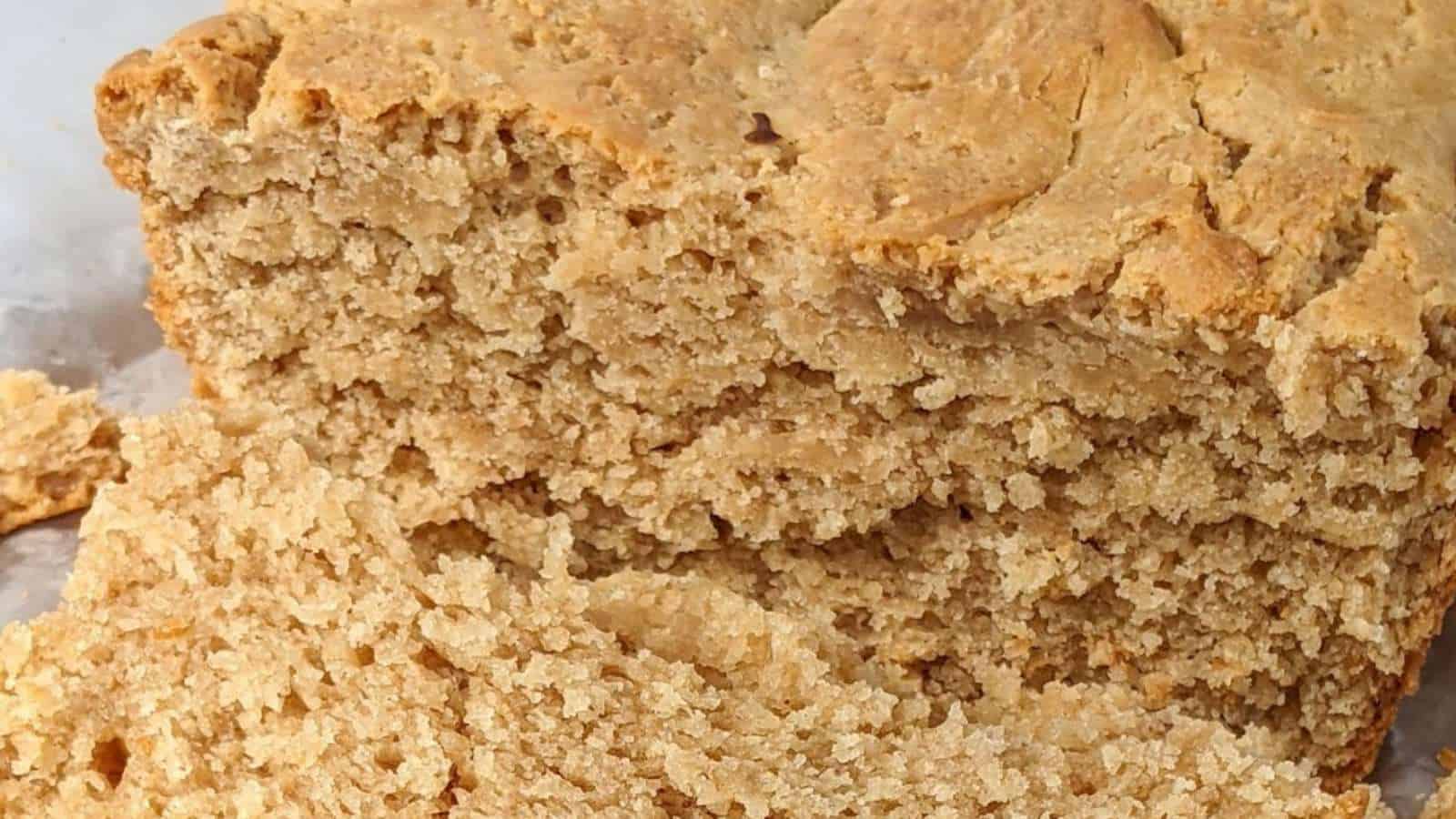 A loaf of sliced brown bread with a crumbly texture, showing its dense interior and rough, golden crust.