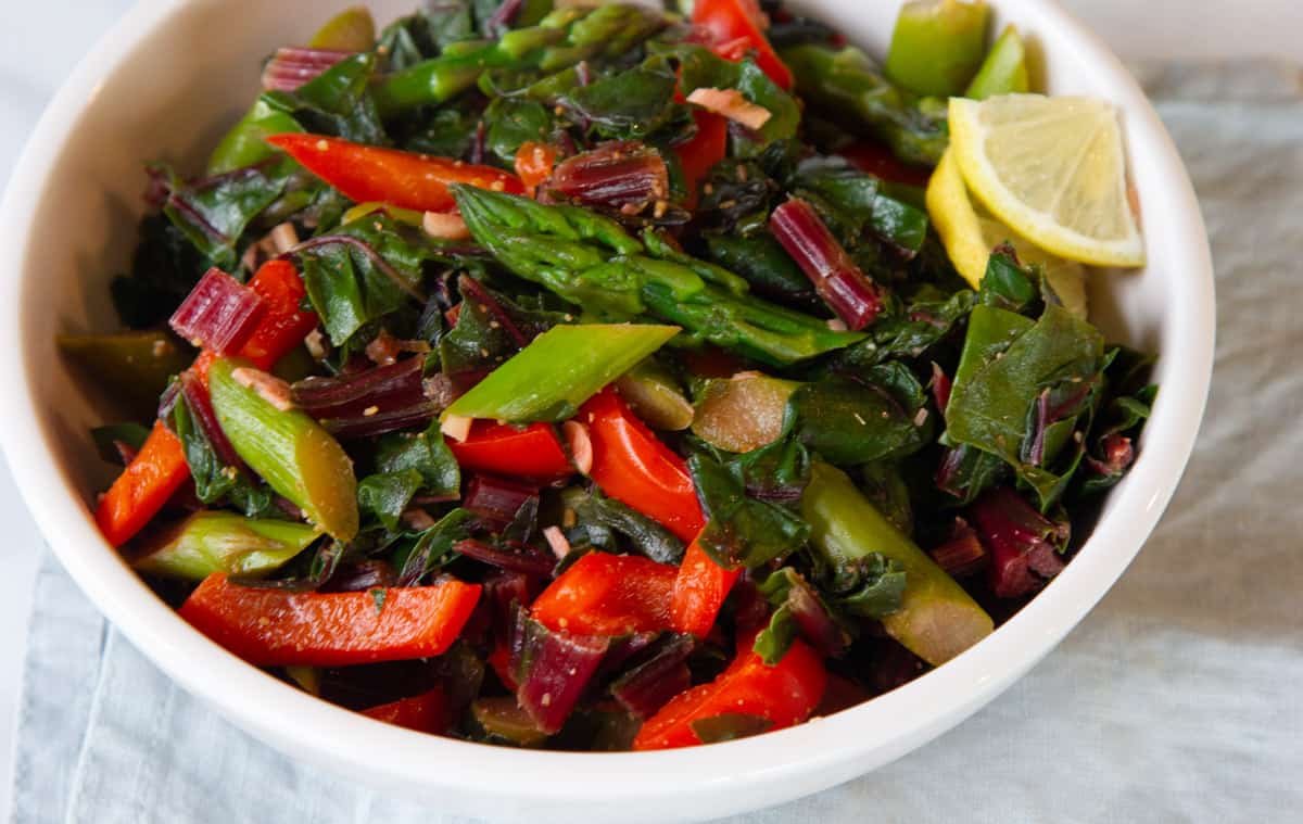 A bowl of vegetables and greens.