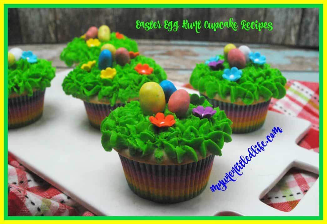 Colorful cupcakes decorated with green frosting, candy eggs, and flower shapes are arranged on a white tray; text overlays promote Easter egg hunt cupcake recipes.