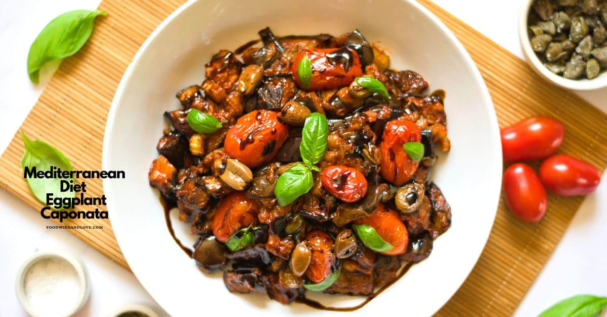 A white bowl filled with Mediterranean eggplant caponata, garnished with basil leaves, surrounded by cherry tomatoes, capers, and a basil leaf. Text on image: “Mediterranean Diet Eggplant Caponata.”.