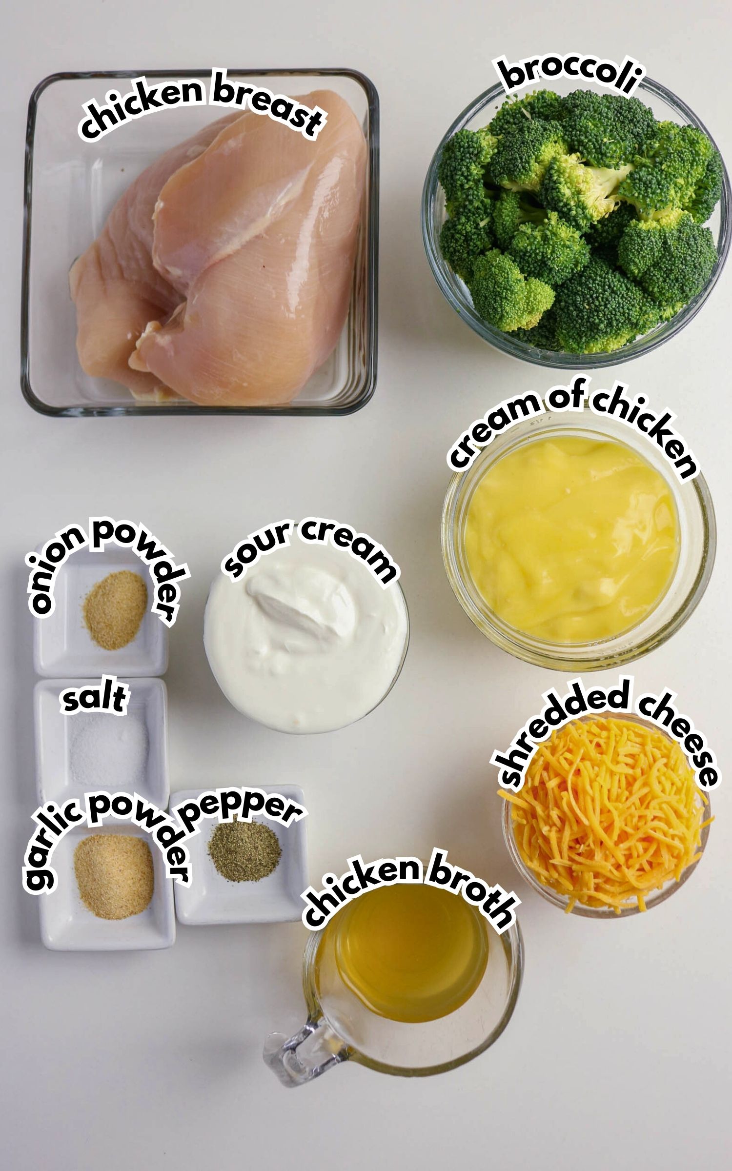 Top-down view of measured ingredients on a white surface, including chicken breast, broccoli, cream of chicken, sour cream, shredded cheese, chicken broth, and seasonings. Labels indicate each item.